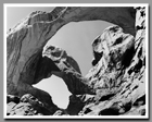 The weathered spans of Double Arch in Arches National Park cleave the sky into thirds.