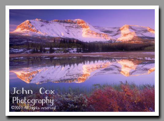 Sofa Mountain reflects brightly in an alpine lake in Waterton National Park, Alberta, Canada.